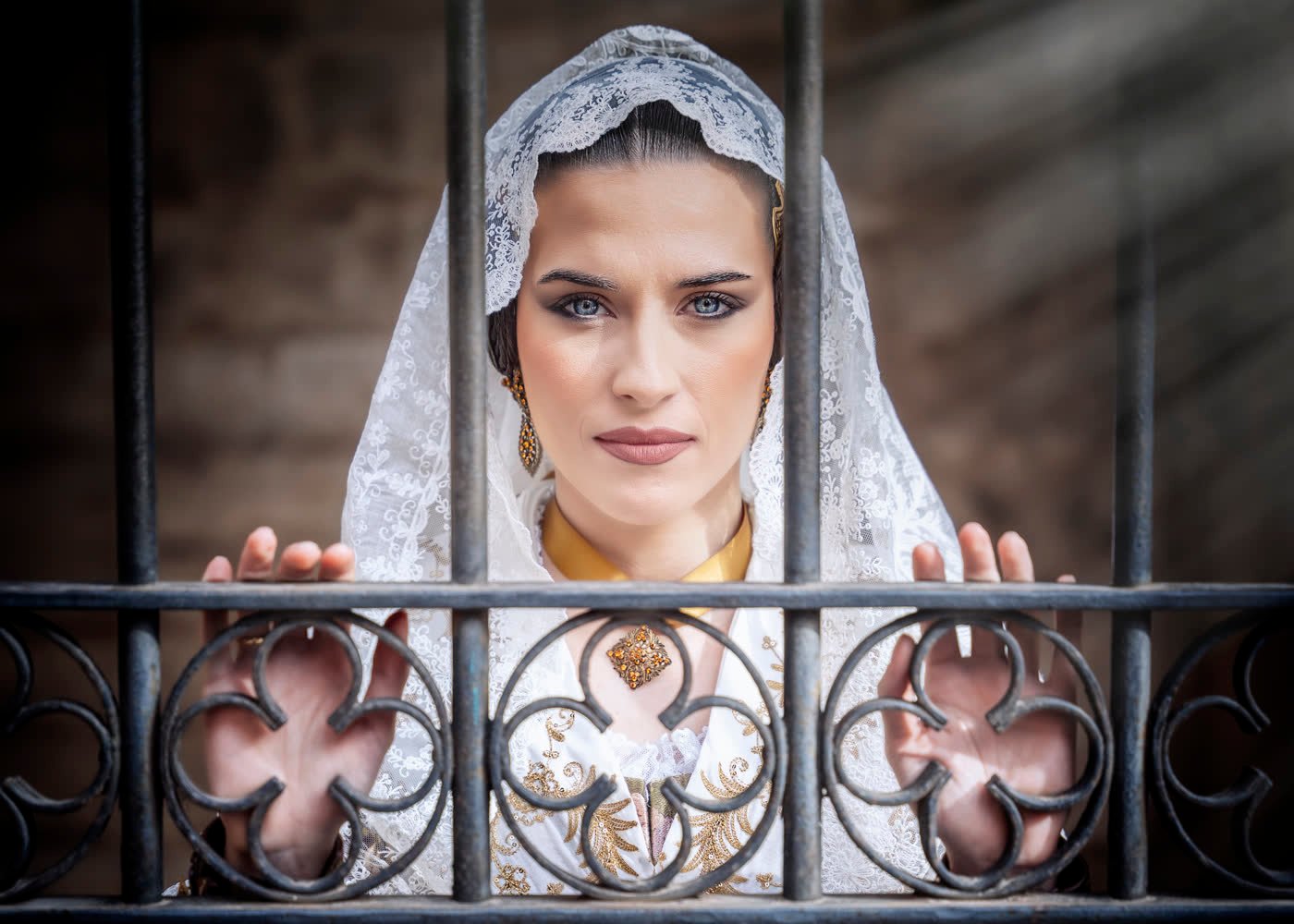 Fallera con mantilla tras una reja de forja, Valencia — César González Photography